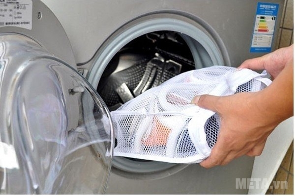 Phân loại và kiểm tra quần áo trước khi giặt.