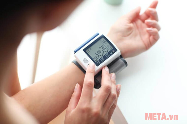 Để tay ngang tim khi đo huyết áp với máy đo huyết áp cổ tay