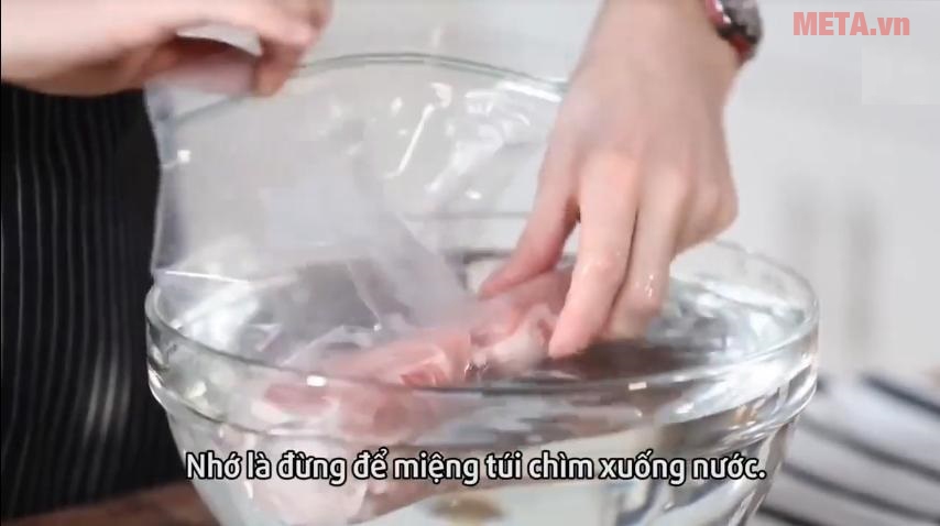 Bước 2: Bây giờ thì từ từ thả vào chậu nước (chú ý không thả ngập mà chừa lại phần miệng túi).