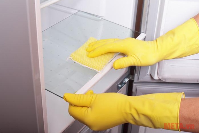 Tháo ngăn tủ rồi lau với hỗn hợp dấm trắng và nước