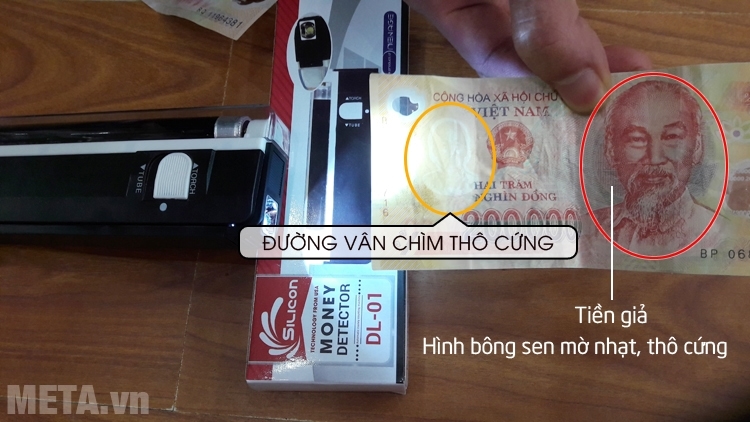 Sử dụng thanh soi tiền Silicon DL-01 để phân biệt tiền polyme mệnh giá 200.000 đồng thật và giả.