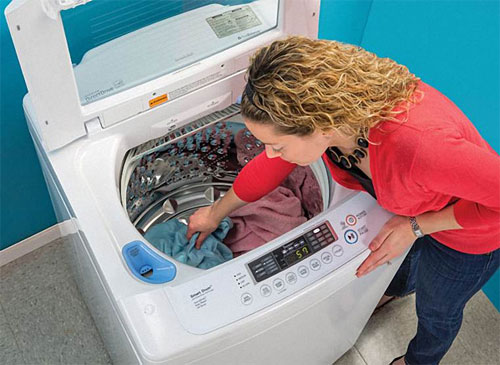 Máy giặt đang vắt lại xả nước do đồ giặt bị dồn về 1 góc