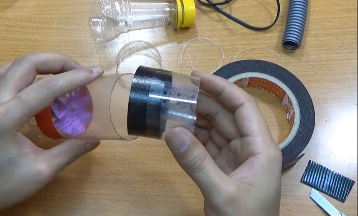 Cắt một miếng nhỏ ở chai nhựa còn lại gắn với phần đầu thân chai chứa motor