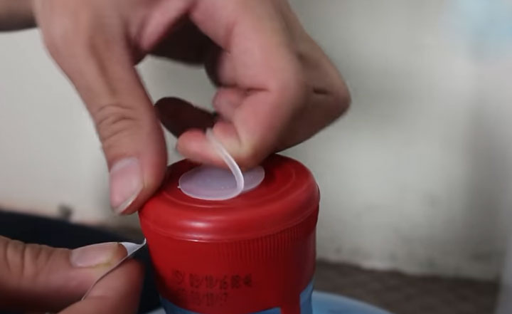 Bóc bỏ tem dán trên đầu bình nước