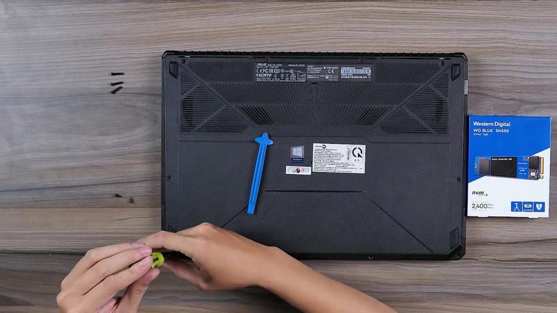 Dùng tua vít tháo hết các ốc ở mặt dưới của laptop ra.