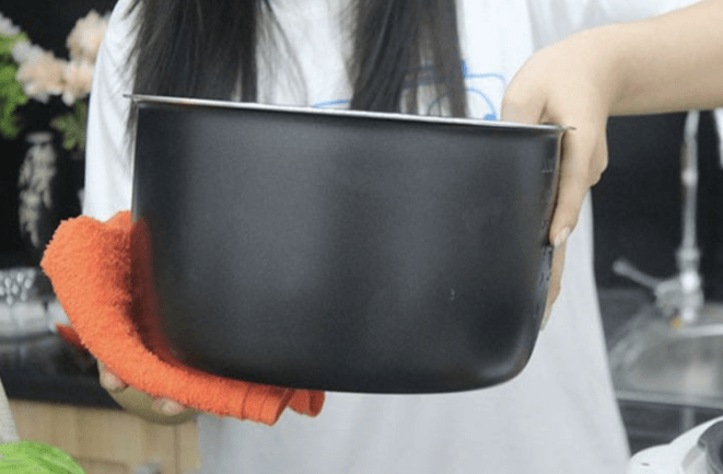 Lau sạch nước bám trên đáy lòng nồi trước khi sử dụng
