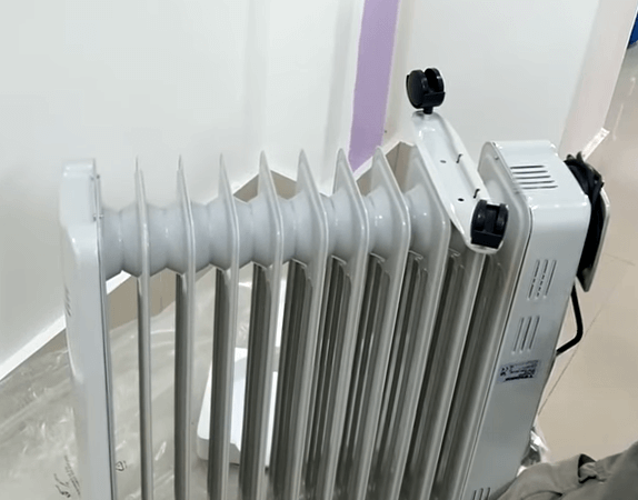 Đặt chân của máy sưởi Tiross vào giữa hai thanh nhiệt