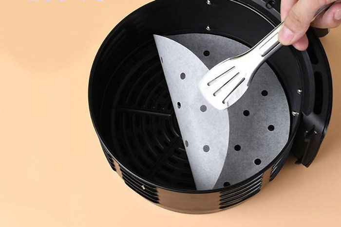 Cách dùng giấy nến cho nồi chiên không dầu - gắp giấy nến ra khỏi nồi