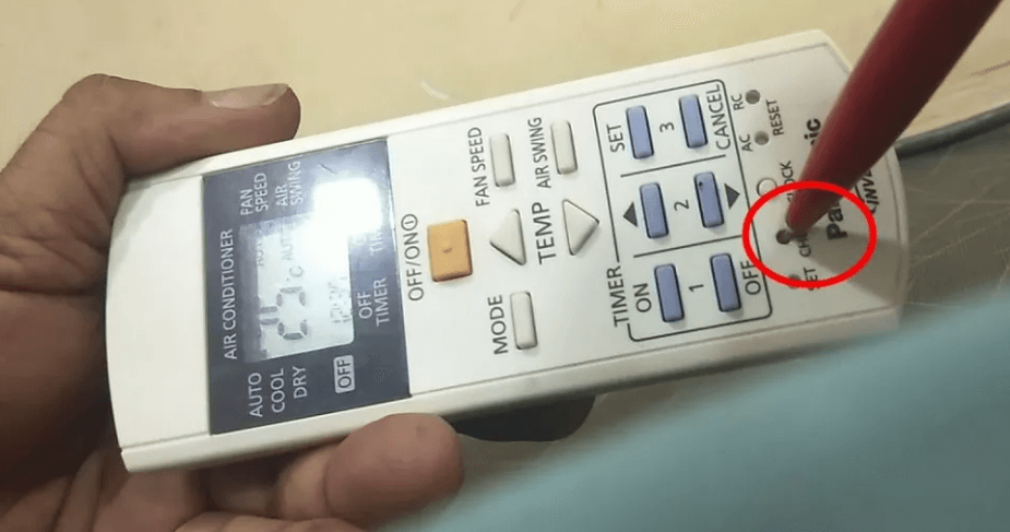 Dùng đầu nhọn của bút để nhấn nút check trên điều khiển điều hòa Panasonic